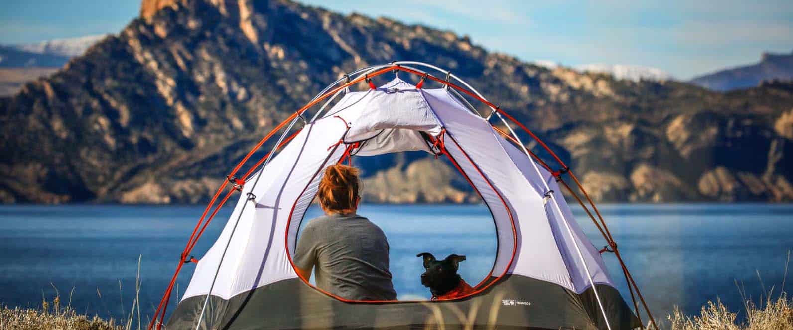Camping mit Hunden Beitragsbild - Frau mit Hund im Zelt